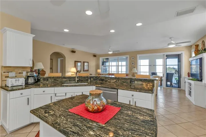 Kitchen featuring stainless steel dishwasher, white cabinets, kitchen peninsula, and sink