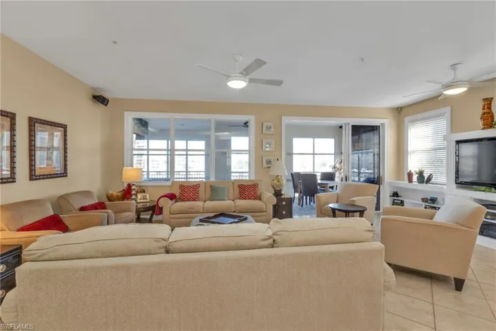 Tiled living room with plenty of natural light and ceiling fan