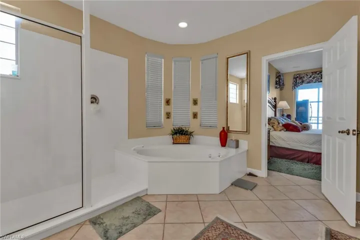 Bathroom with tile patterned flooring and shower with separate bathtub