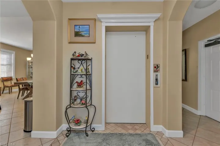 Hall with light tile patterned floors and elevator