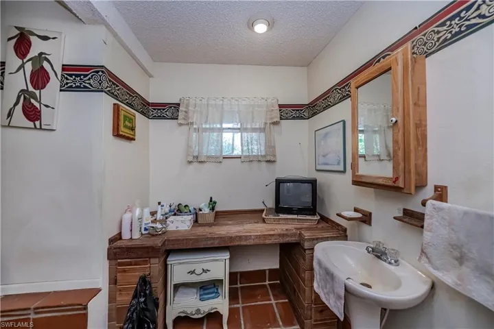 Bathroom featuring a textured ceiling and a sink
