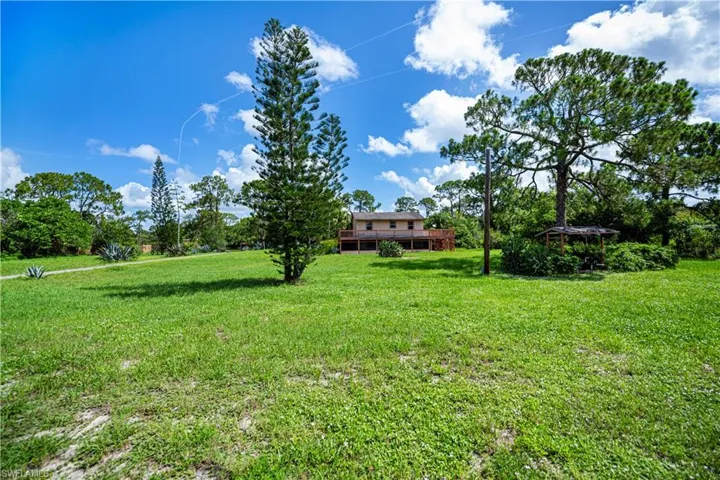 View of grassy yard with a deck