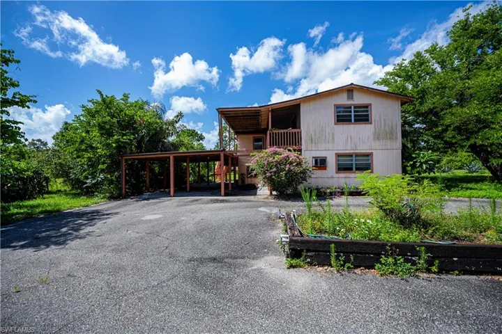 View of front facade featuring asphalt driveway