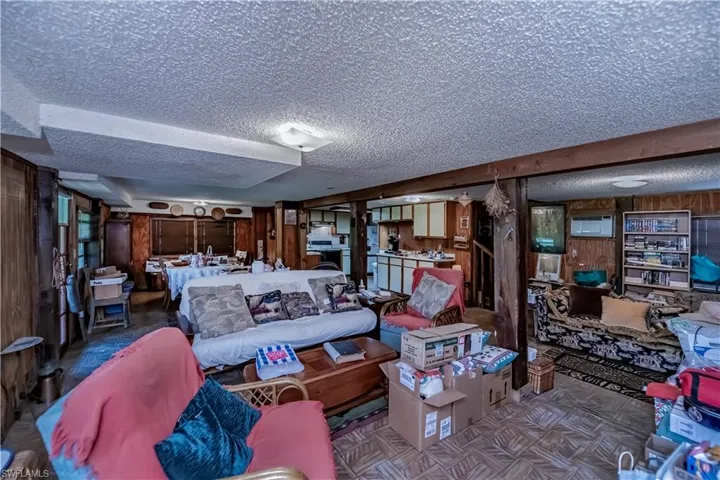 Living area with a textured ceiling and wooden walls