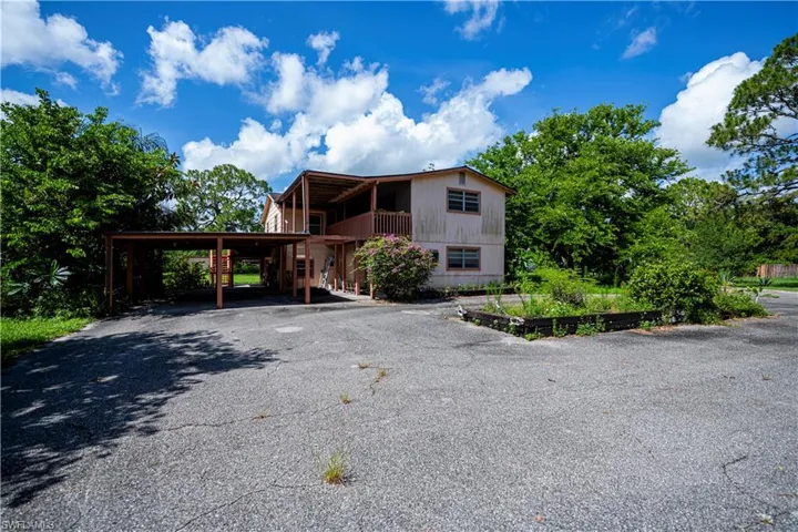 View of front of property featuring a carport and driveway