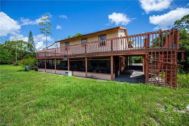 Back of property featuring a wooden deck, a yard, a patio area, and stairway