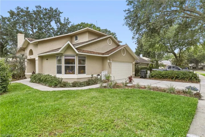 Stucco exterior with a two-car garage, bay window, and arched entry