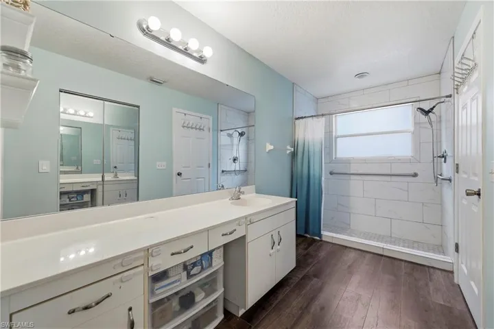 Bathroom featuring dark wood-finish flooring and light blue walls