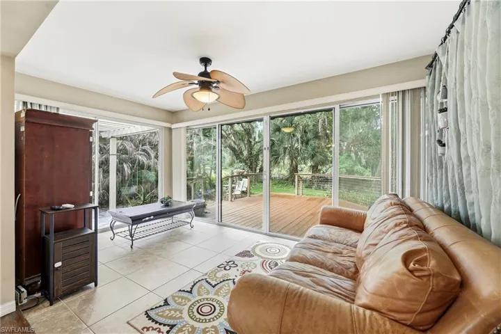 Living area with expansive sliding glass doors, overhead ceiling fan, and tile flooring