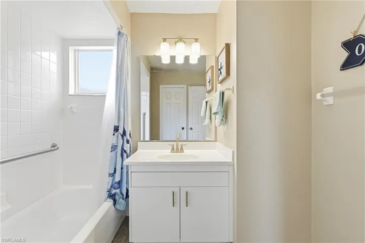 White vanity with gold-tone hardware, undermount sink, and coordinating faucet