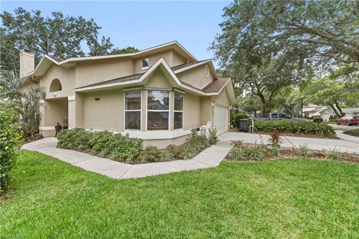 Stucco exterior with a prominent bay window and an attached garage