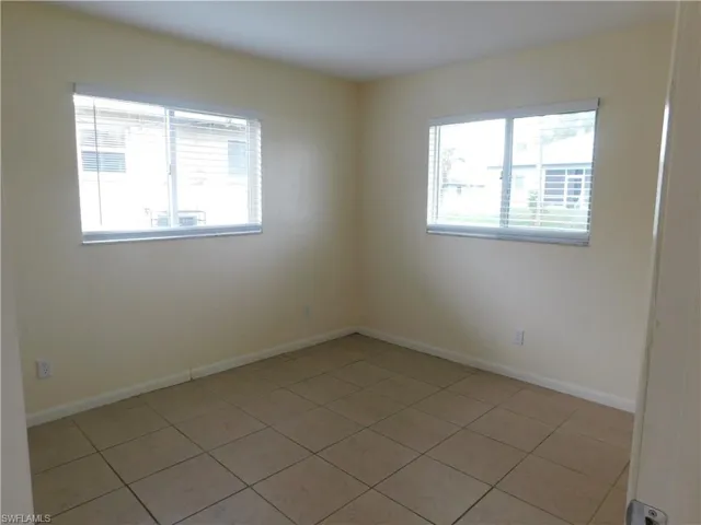 Tiled Guest bedroom featuring two large windows giving great natural light