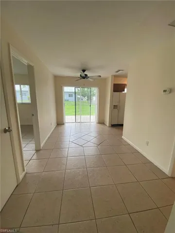 Dining area overlooks rear year with sliding glass door to patio