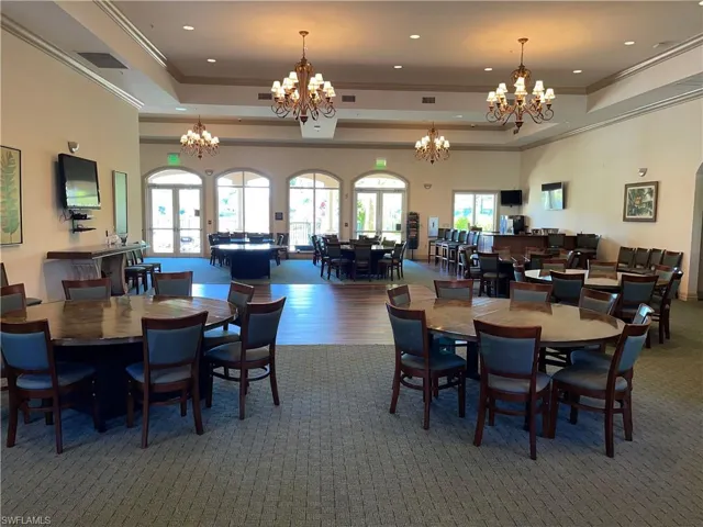Dining room with a raised ceiling, dark hardwood / wood-style floors, a high ceiling, ornamental molding, and a notable chandelier