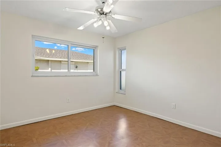 Unfurnished room with light parquet floors and ceiling fan