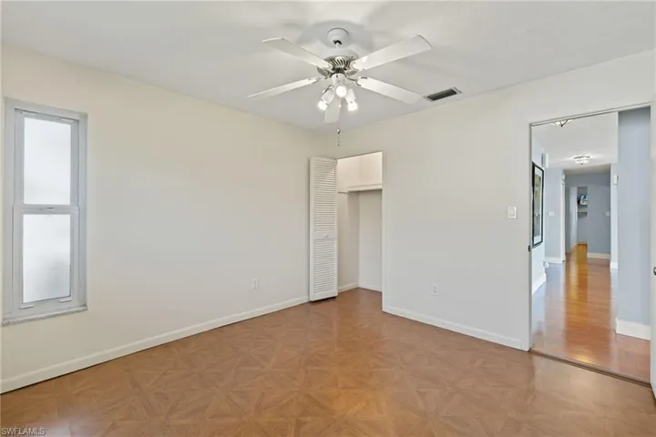 Unfurnished bedroom featuring a closet, light parquet floors, and ceiling fan