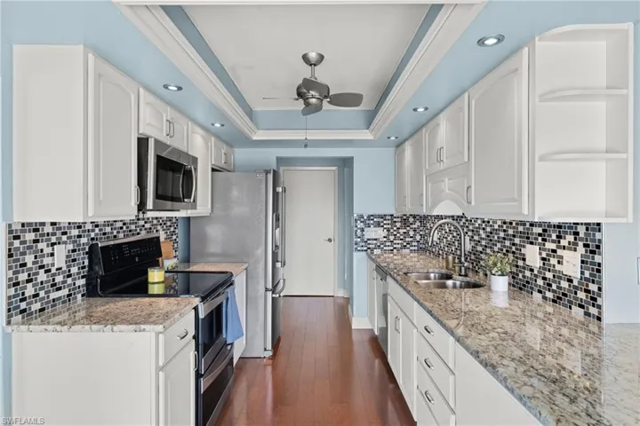 Kitchen featuring stainless steel appliances, sink, dark hardwood / wood-style flooring, and white cabinets