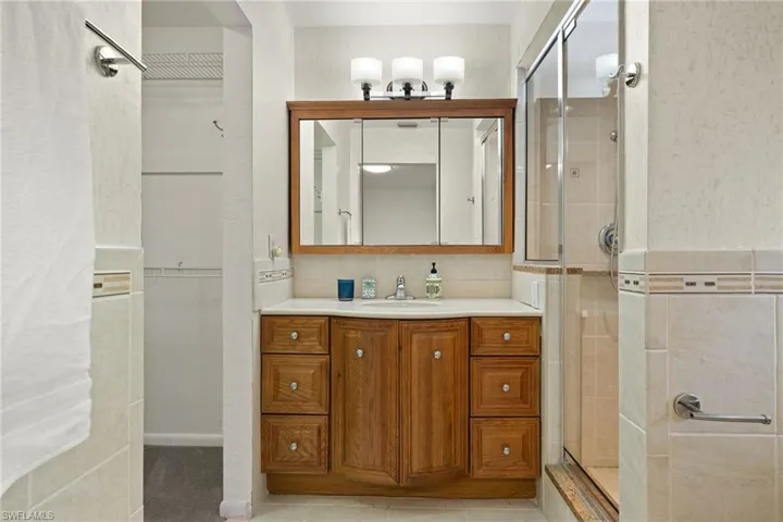 Bathroom featuring vanity, tile patterned flooring, and walk in shower