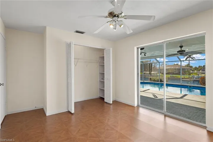 Unfurnished bedroom featuring access to outside, a closet, light parquet flooring, and ceiling fan