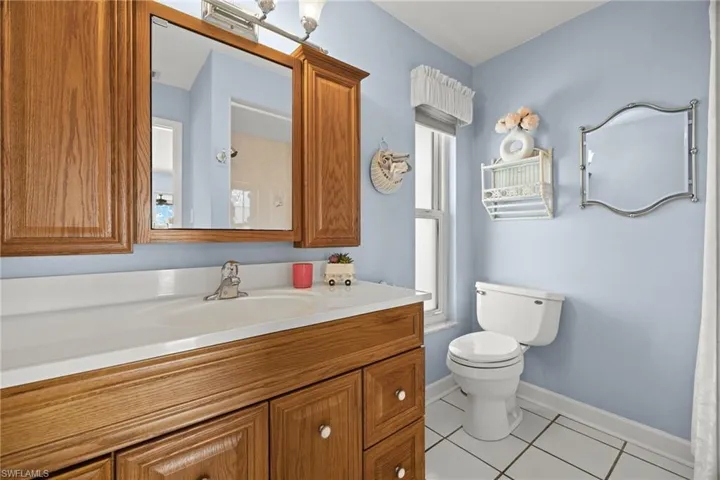 Bathroom with vanity, toilet, and tile patterned floors