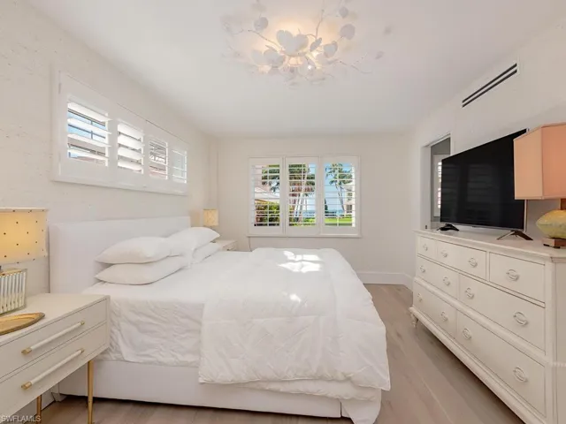 Master Bedroom featuring multiple windows, light wood-style floors, and a chandelier