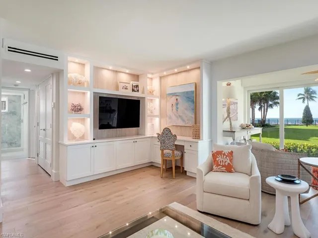 Living area featuring plenty of natural light, light wood finished floors, built in study area, built in shelves, and recessed lighting