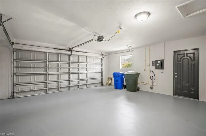 Garage featuring electric panel and a garage door opener