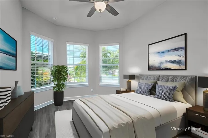 Virtually staged- Front Bedroom featuring ceiling fan, dark hardwood / wood-style flooring, and multiple windows