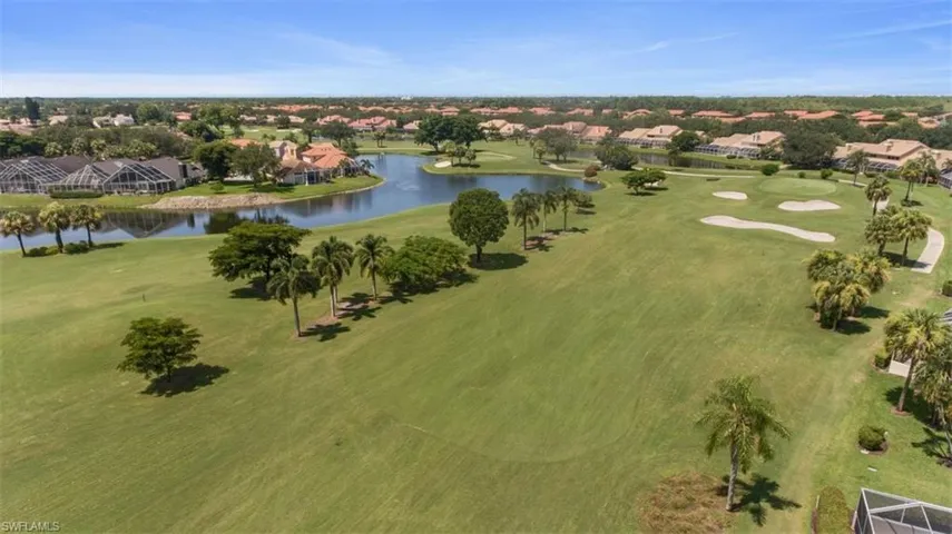 Aerial view of residential area featuring a large body of water and a golf course