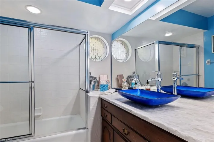 Full bathroom with vanity, shower / bath combination with glass door, and recessed lighting
