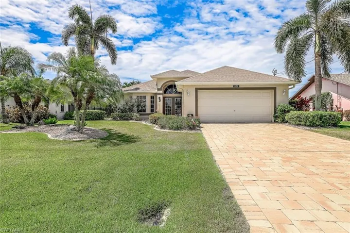 View of front of house with a garage and a front yard