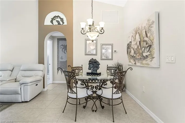 Tiled dining area with high vaulted ceiling and a chandelier