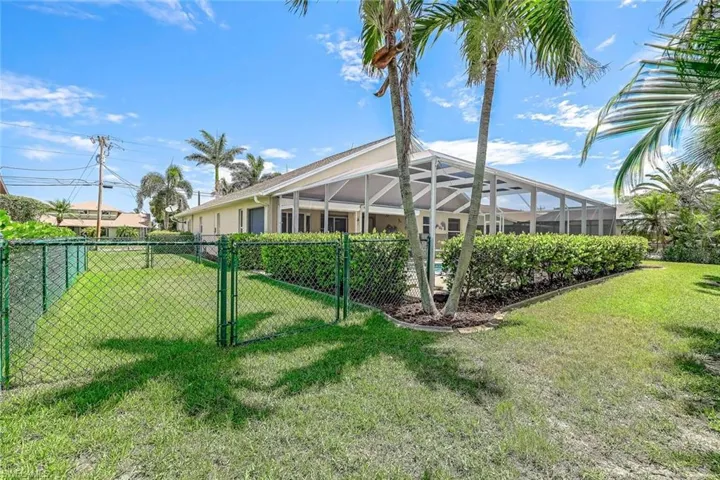 View of fenced in area of the yard and mature landscaping