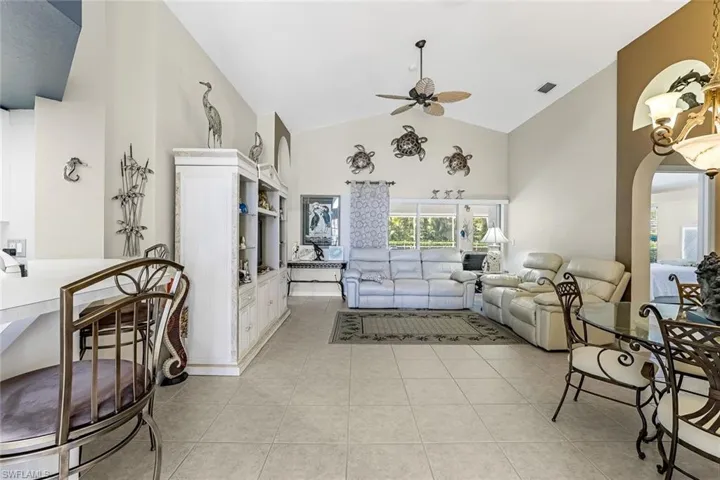 Tiled living room with high vaulted ceiling and ceiling fan