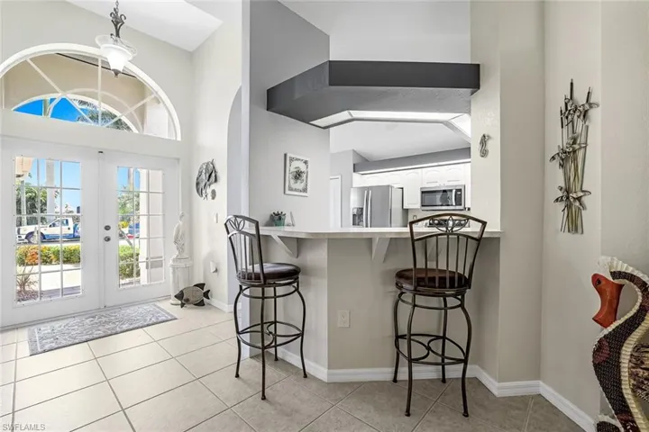 Entryway featuring french doors and light tile floors