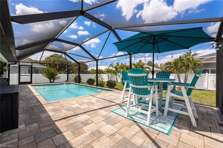 The property features a screened-in pool area with a paved patio, offering a private outdoor space
