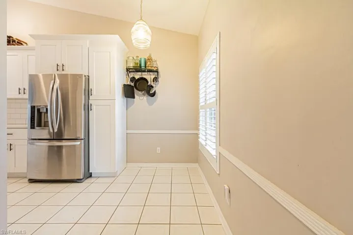 Kitchen featuring lofted ceiling, sink, white cabinets, and stainless steel appliances