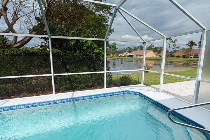 View of pool with a patio and glass enclosure