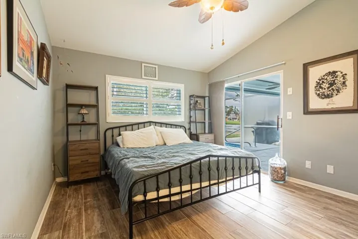 Bedroom with lofted ceiling, light wood-type flooring, and ceiling fan