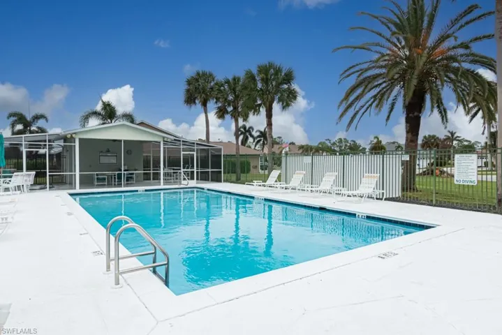 View of pool featuring a patio and glass enclosure