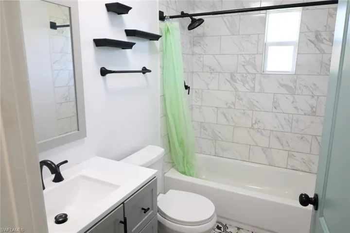 Full bathroom featuring shower / bath combination with curtain and vanity