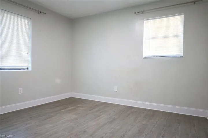 Spare room with baseboards and wood finished floors