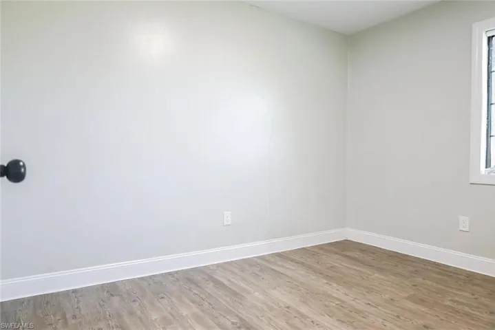 Empty room featuring baseboards and wood finished floors