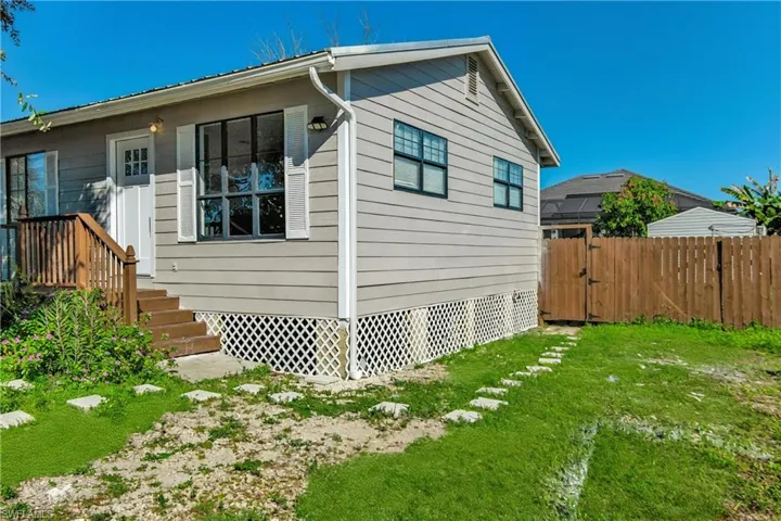 View of side of home with a gate
