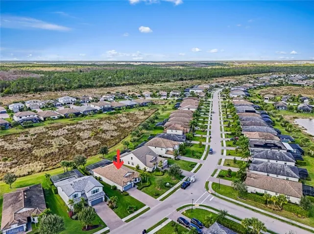 Aerial view of property and surrounding area featuring nearby suburban area