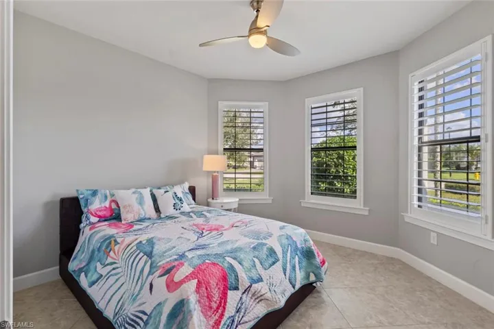Bedroom with ceiling fan and light tile patterned floors