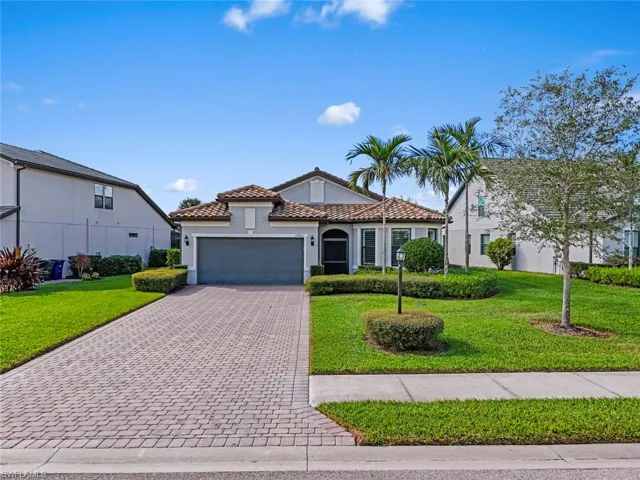 Mediterranean / spanish-style home featuring stucco siding, a front lawn, decorative driveway, a garage, and a tile roof