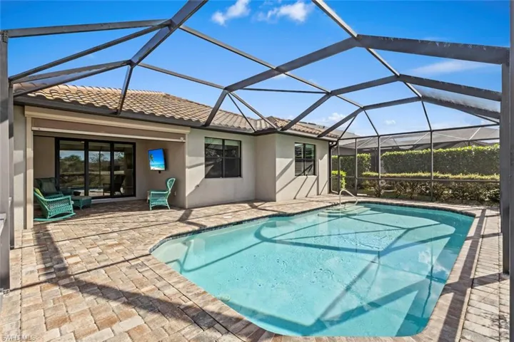 Outdoor pool featuring a lanai, a patio, and a sunroom