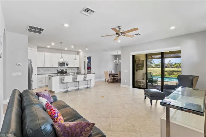 Living area with a ceiling fan, recessed lighting, a chandelier, and light tile patterned floors