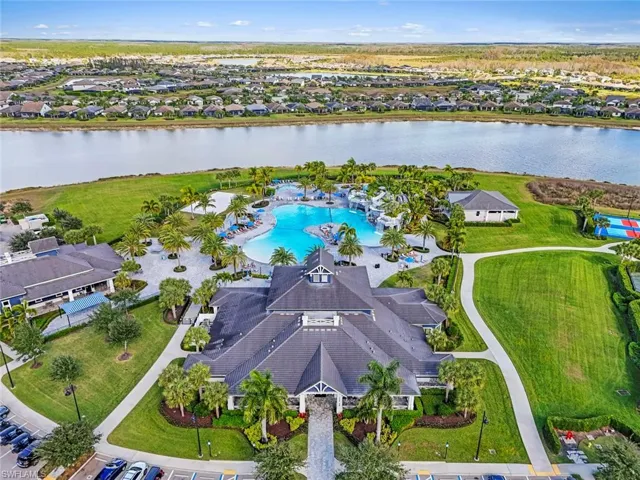 Aerial perspective of suburban area with a large body of water and a pool area